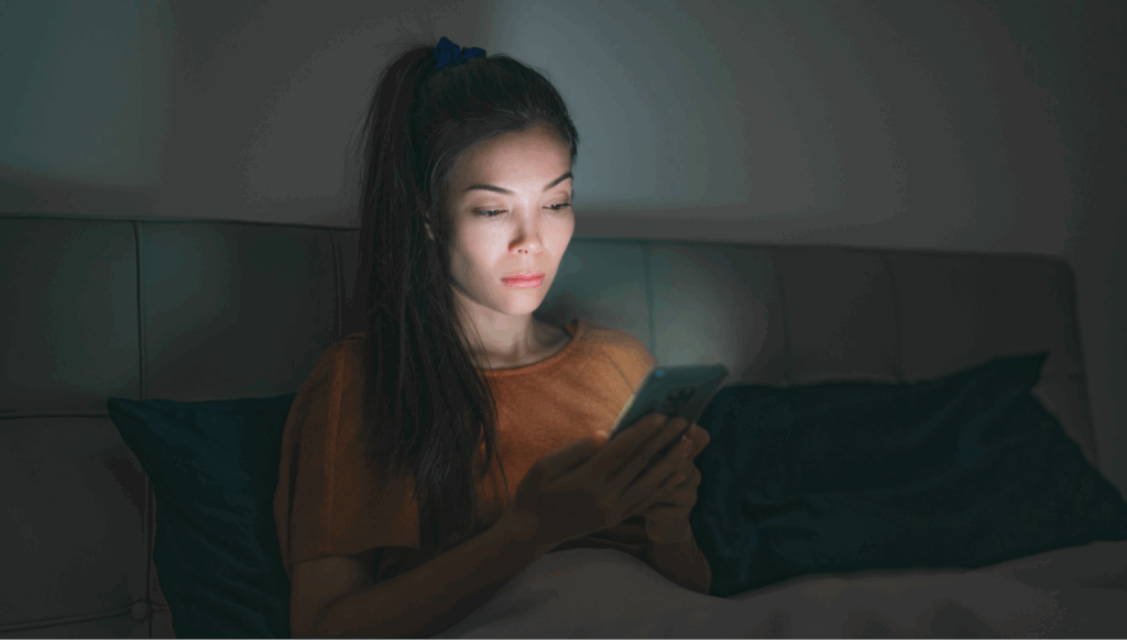 Girl scrolling late at night with one eye open while chatting with live chat support on an ecommerce site.